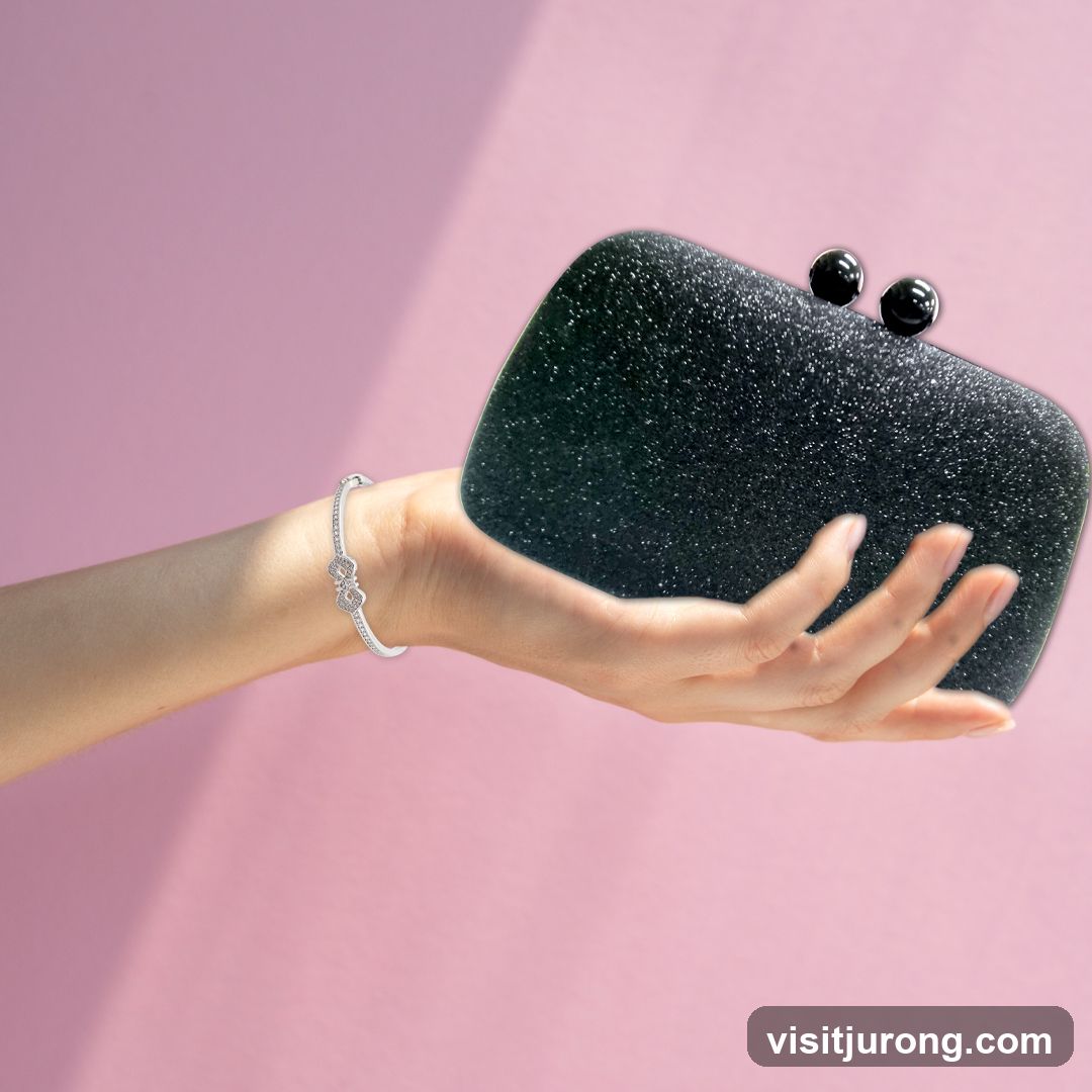 Hand holding a black clutch bag