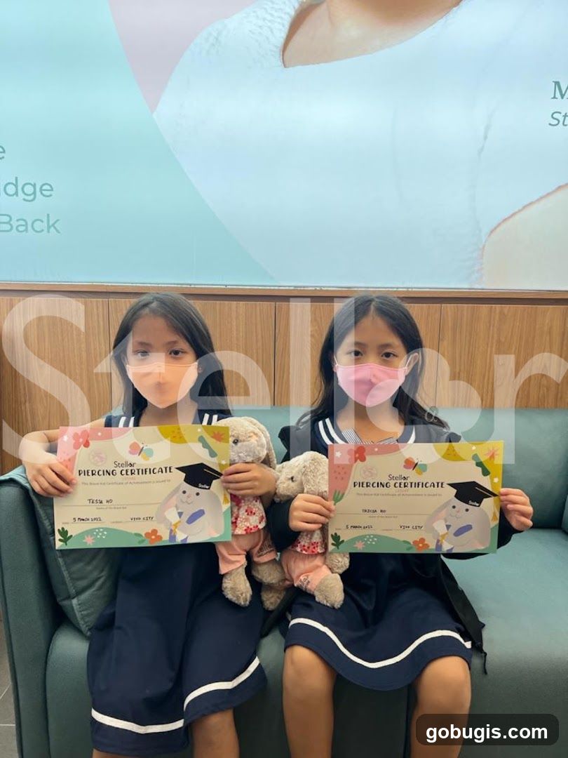 Two girls holding piercing certificates