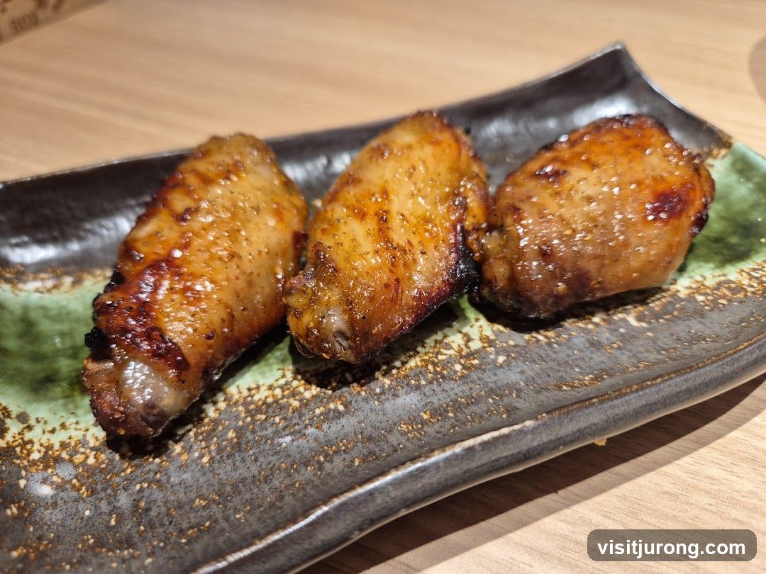 Three glazed chicken wings on a plate