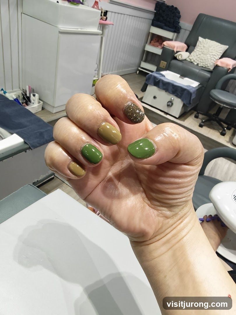 Woman's hand with green and brown nails