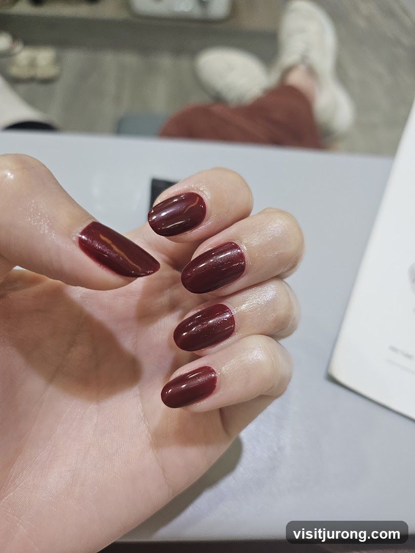 Close-up of manicured hand with dark red nails