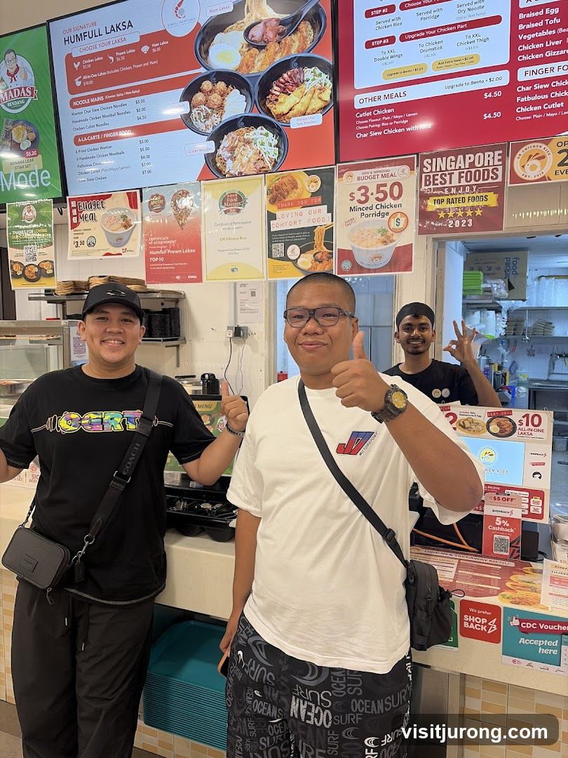 People posing in front of a food stall menu