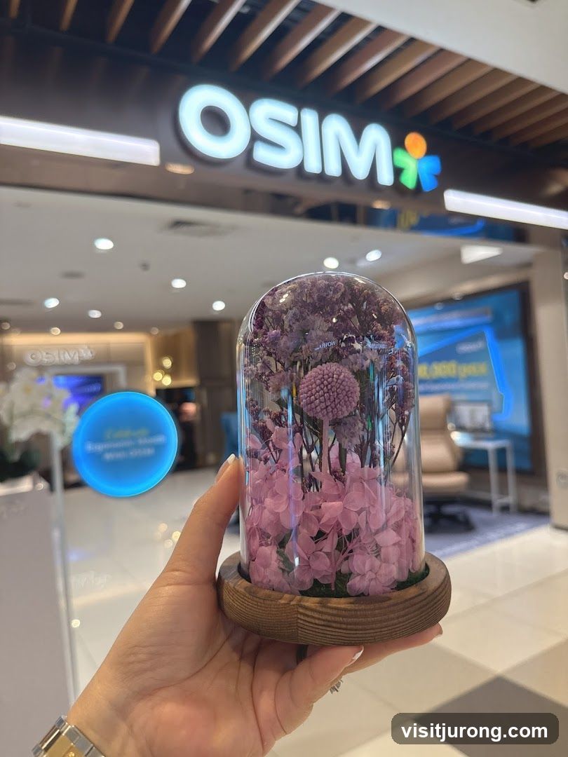 Hand holding a preserved flower arrangement in front of an OSIM store
