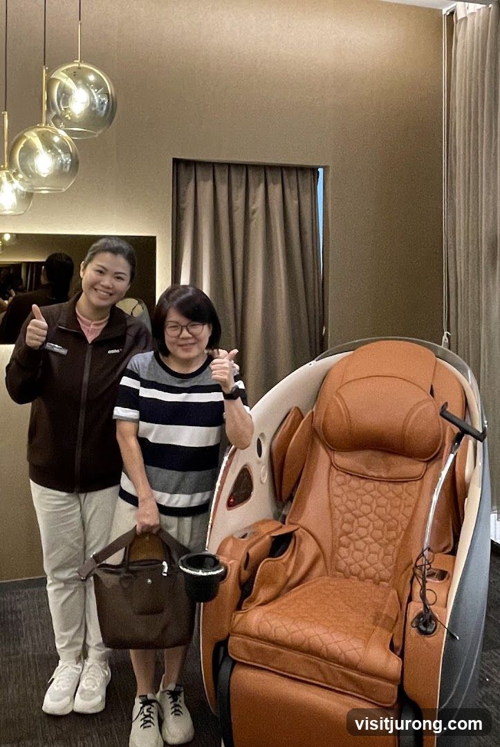 Two women posing with a massage chair