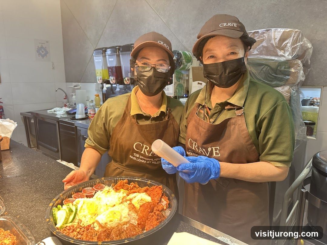 Two staff members with a large platter of food