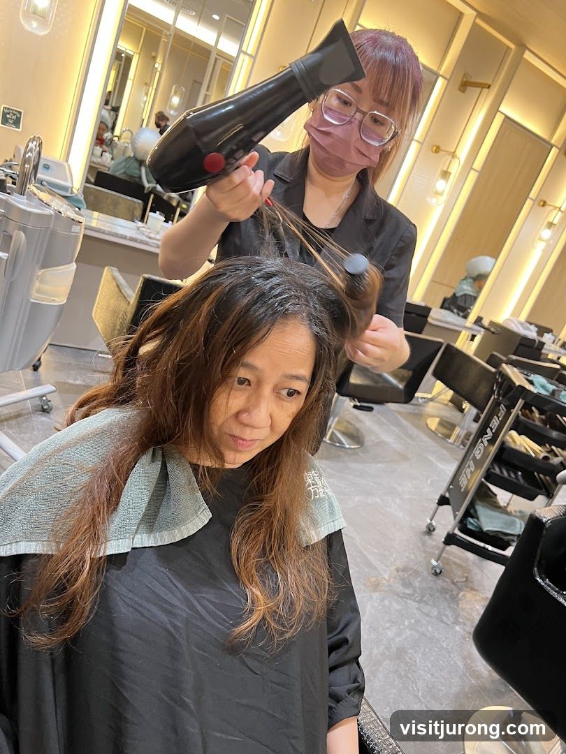 Hairdresser drying client's hair