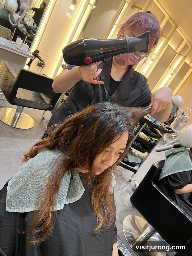 Hairdresser drying client's hair