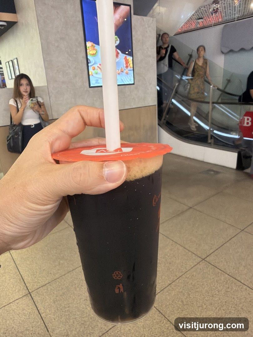 Person holding a dark beverage