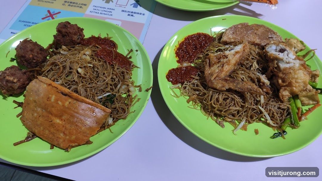 Two plates of noodles with fried items