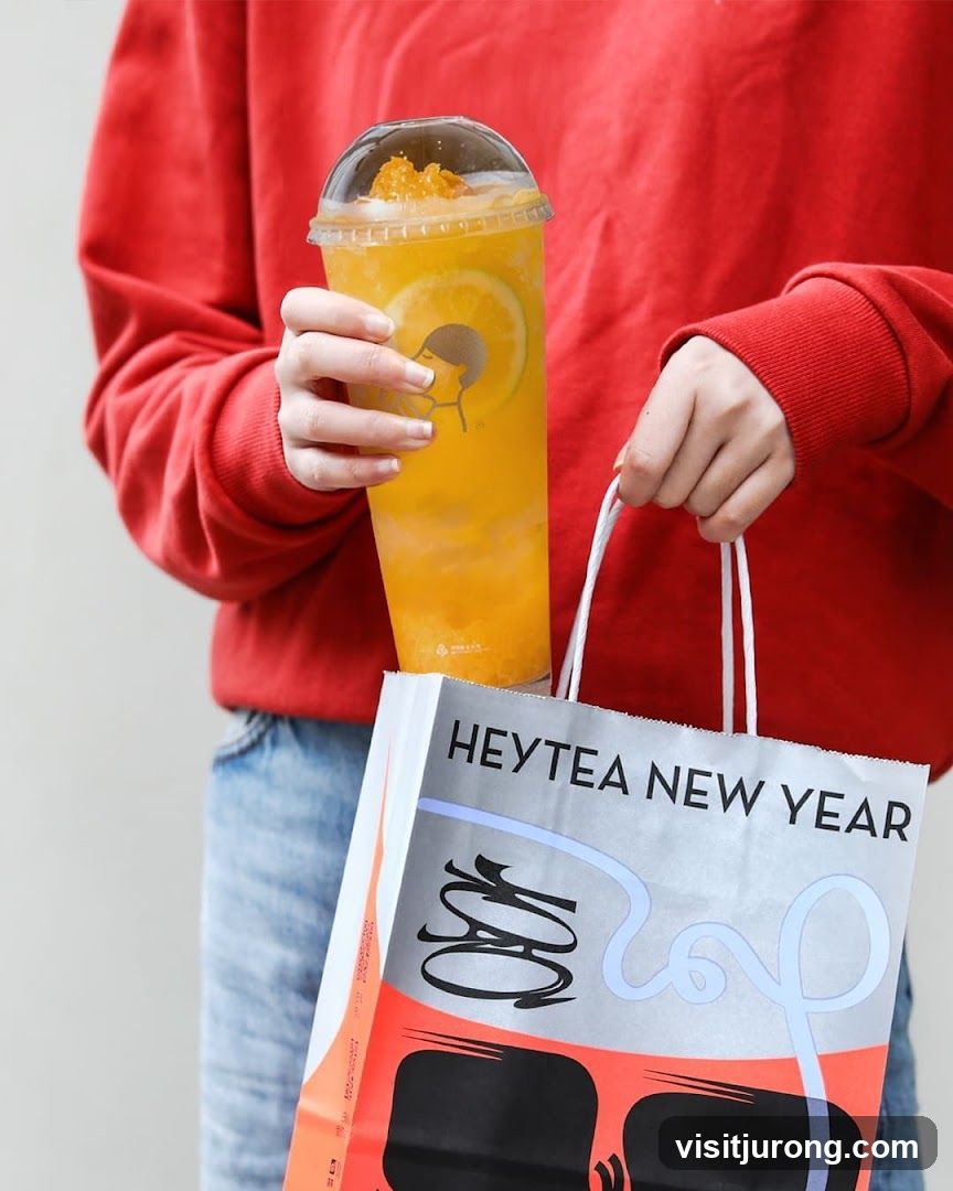 Person holding a Heytea drink and bag