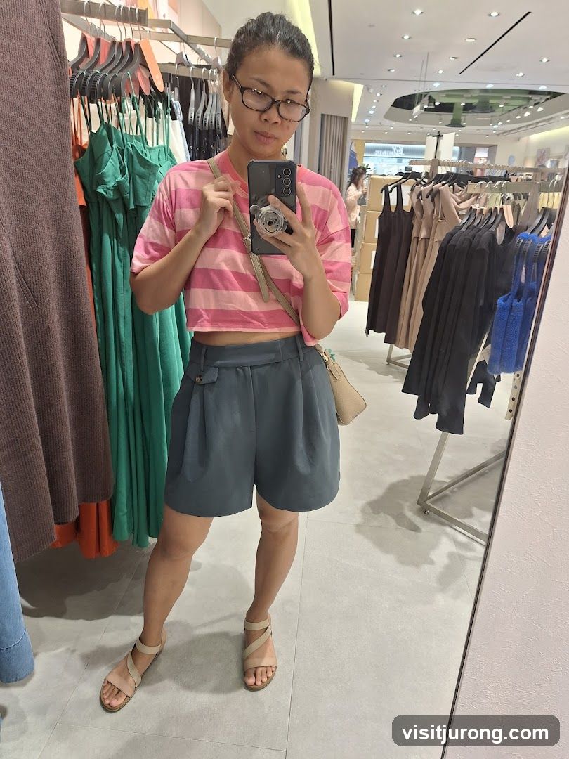 Woman taking a mirror selfie in a clothing store