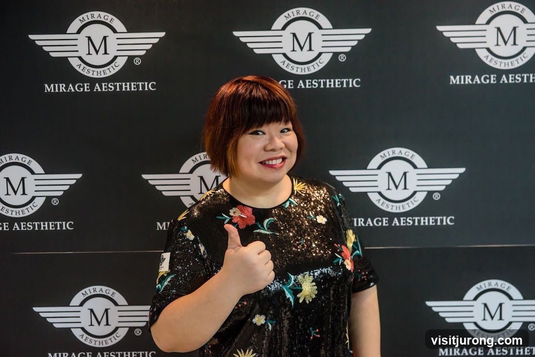 Woman giving a thumbs up in front of a branded backdrop