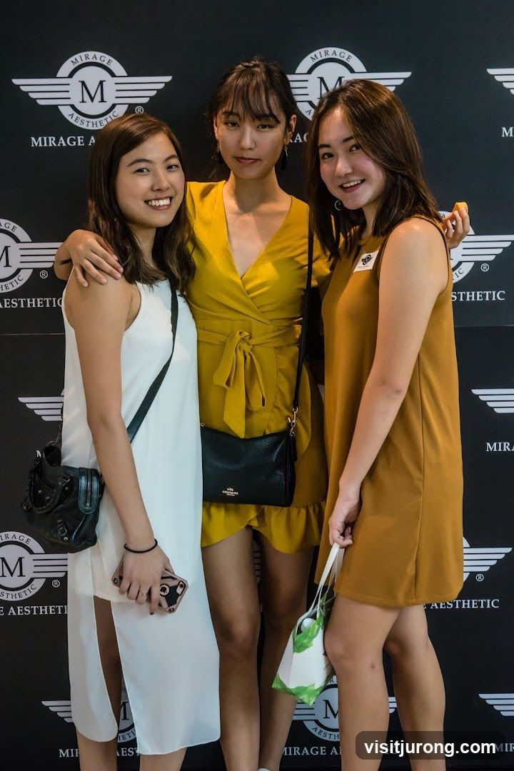 Three women posing in front of a branded backdrop