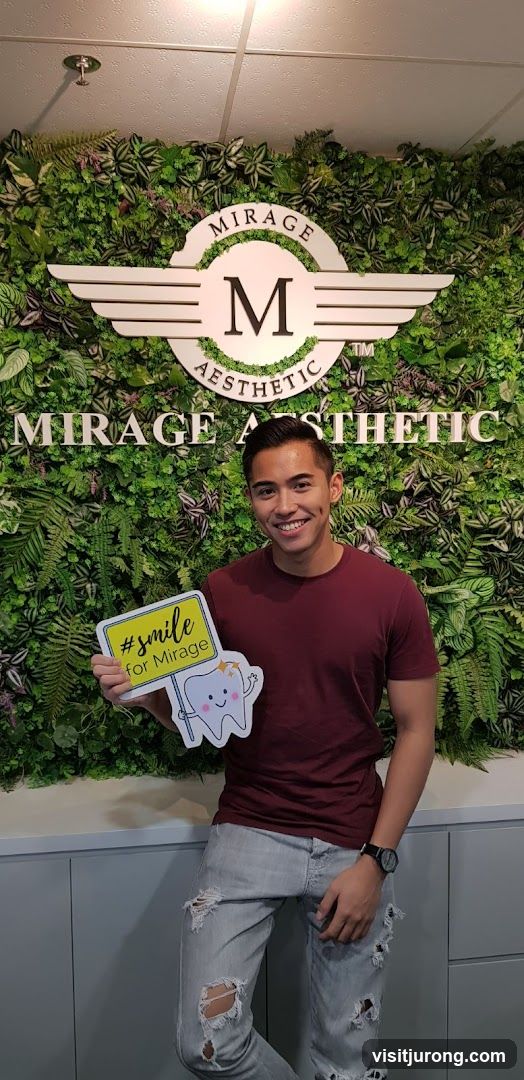 Man holding a sign in front of a green wall with a logo