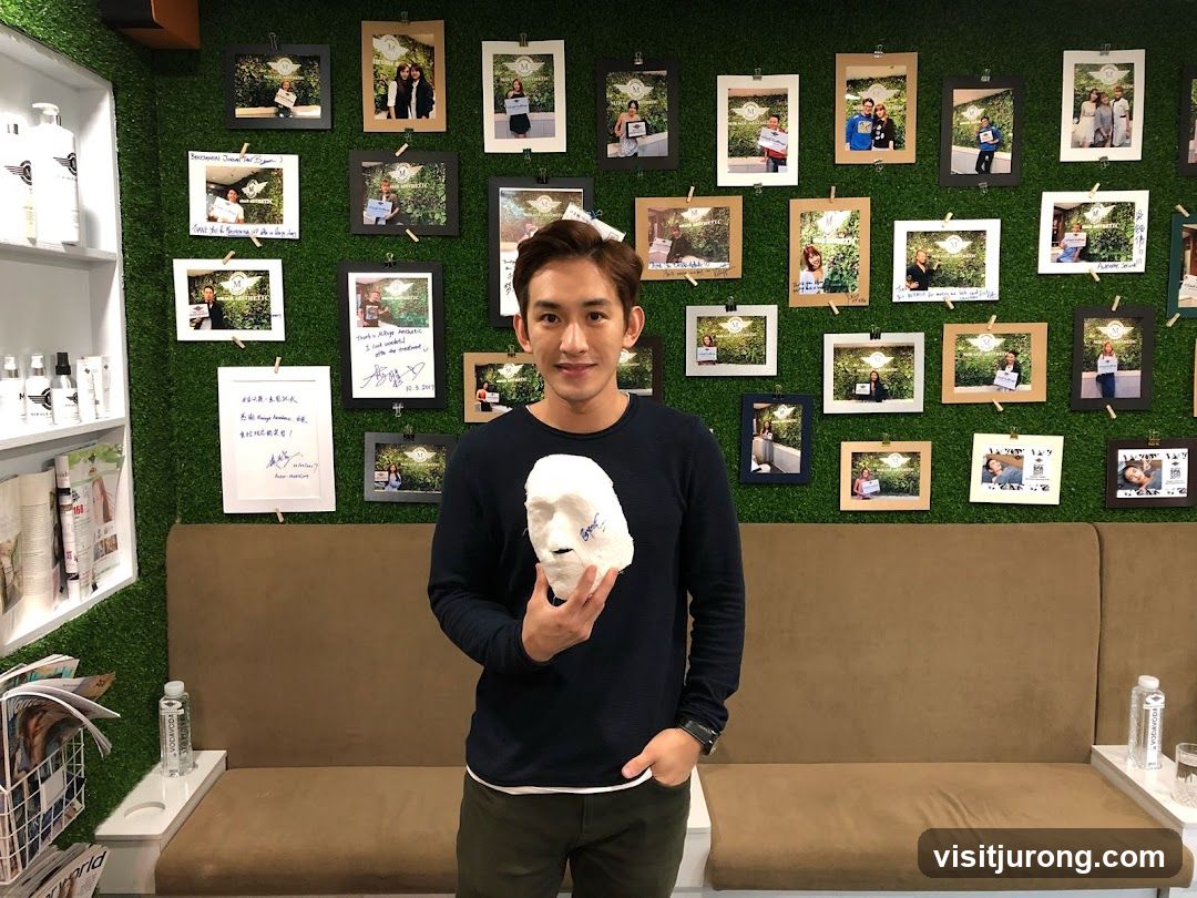 Man Holding a Mask in Front of a Wall of Photos