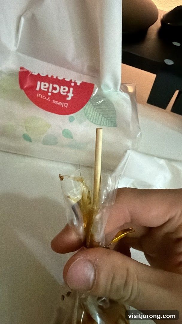 Hand holding a lollipop with facial tissues in the background