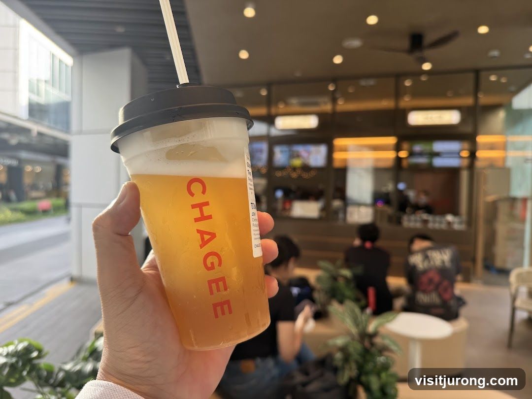 Hand holding a beverage with a shop interior in the background