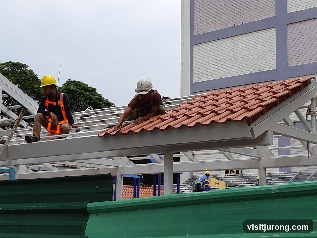 Construction workers installing roof tiles