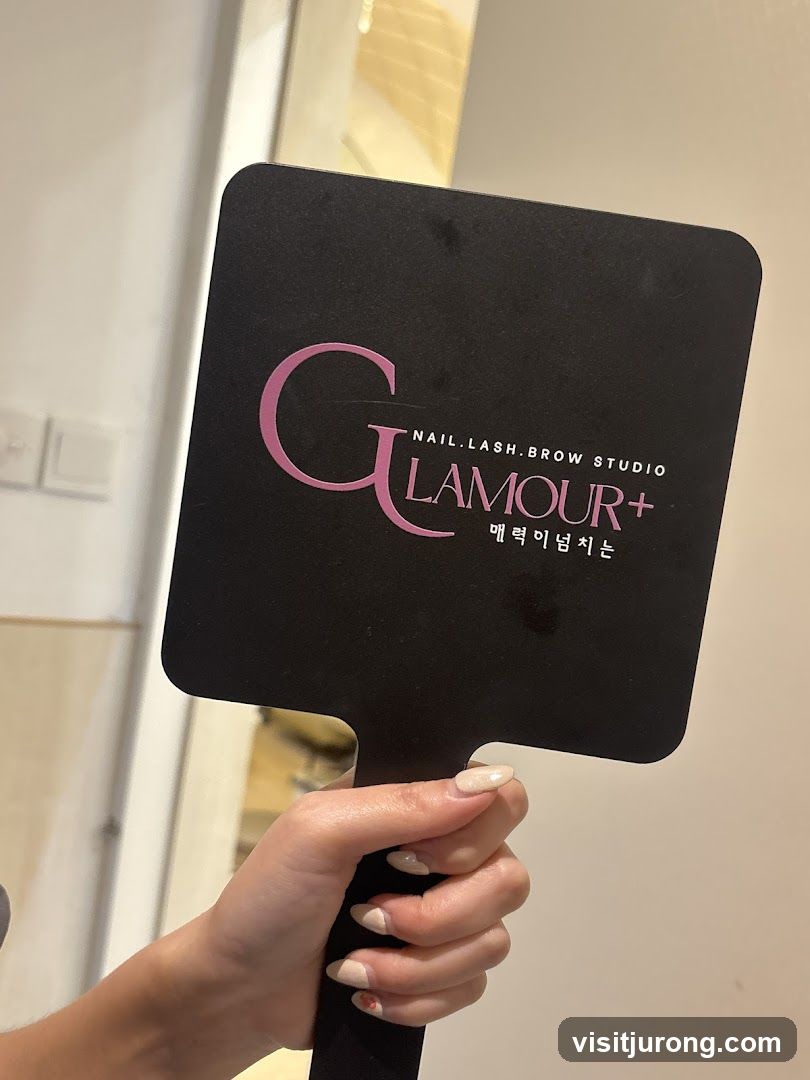 Hand holding a mirror with salon logo
