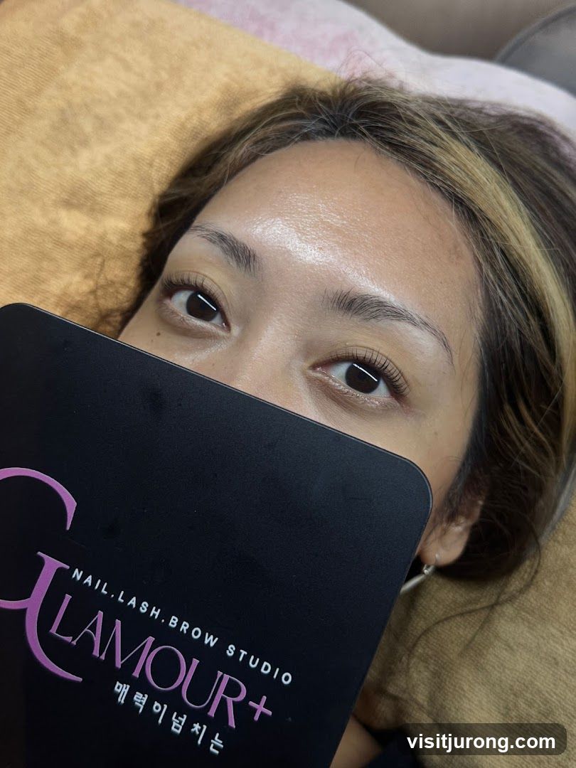 Woman with Eyelash Extensions Holding a Studio Card