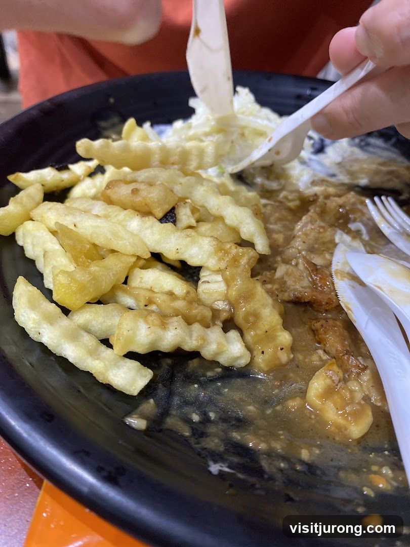 Half-eaten meal with fries and gravy