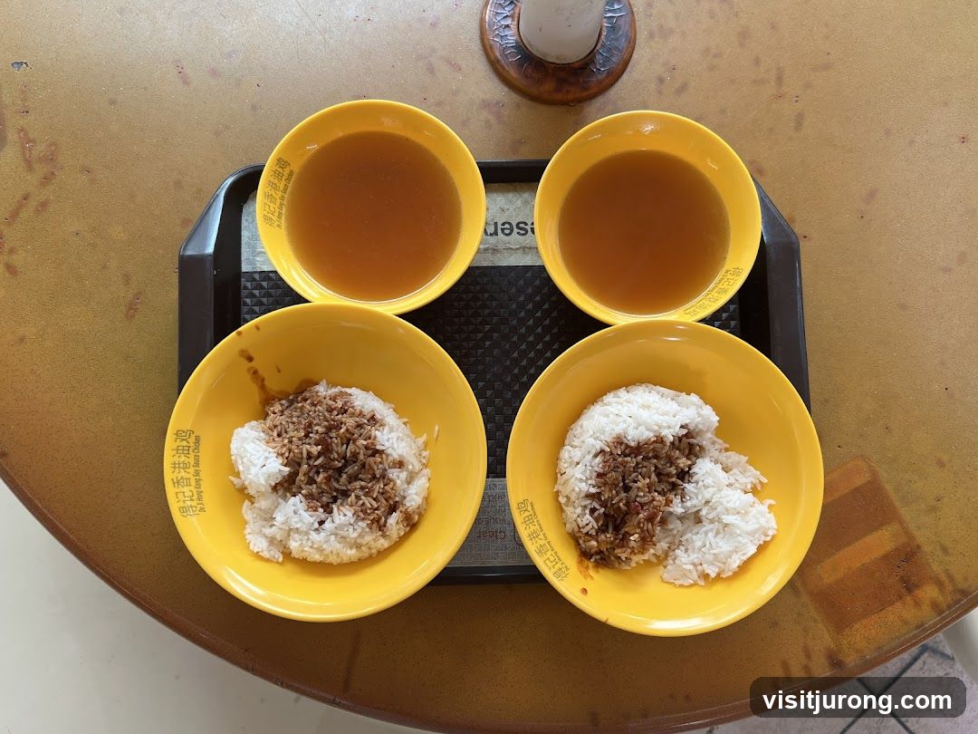 Two bowls of rice with sauce and two bowls of soup