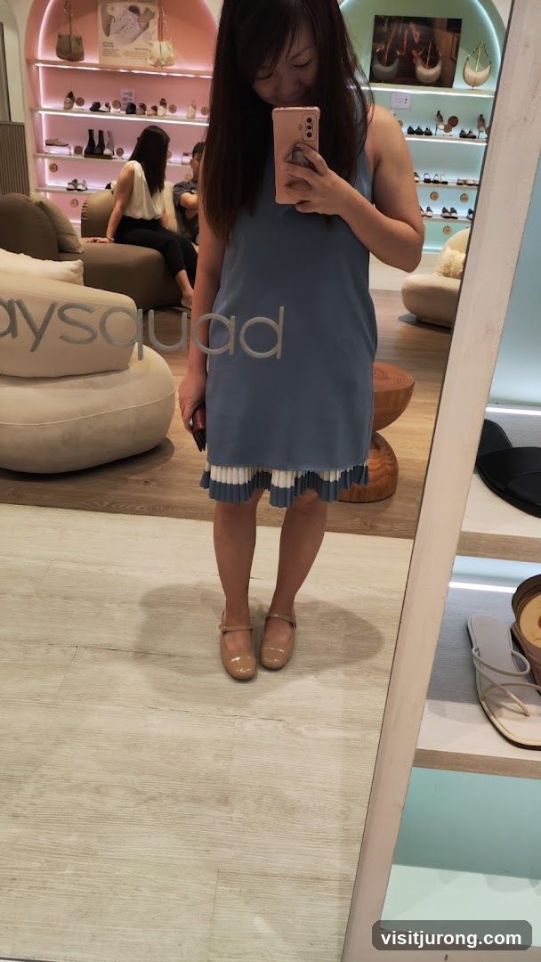 Woman in Blue Dress Taking Mirror Selfie in Shoe Store