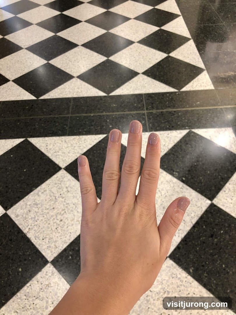 Hand with light pink nail polish