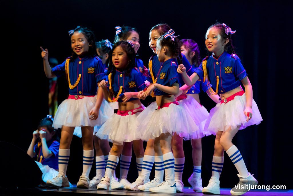 Children in matching outfits performing on stage