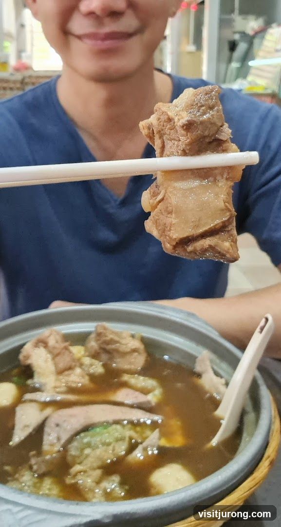 Person holding meat over a bowl of soup