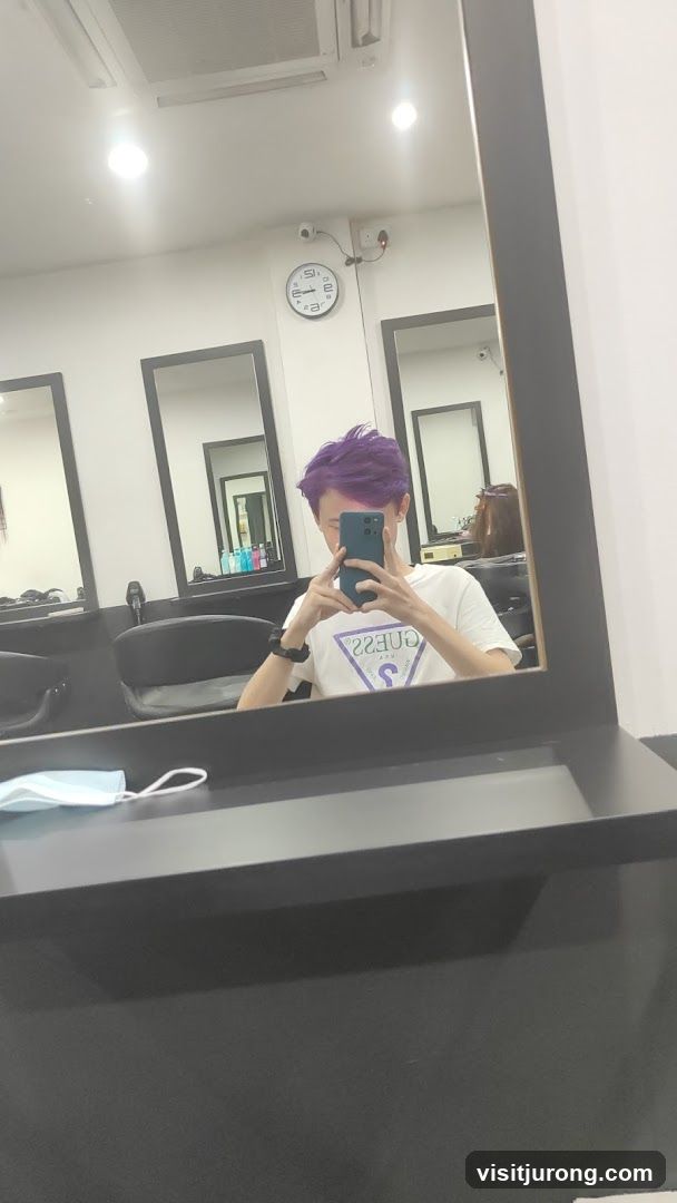 Person with purple hair taking a mirror selfie