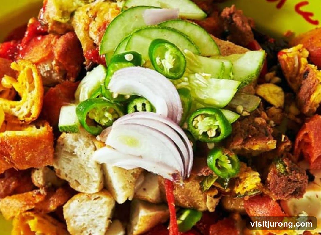 Close-up of a dish with fried tofu, cucumber, onion, and chili peppers.