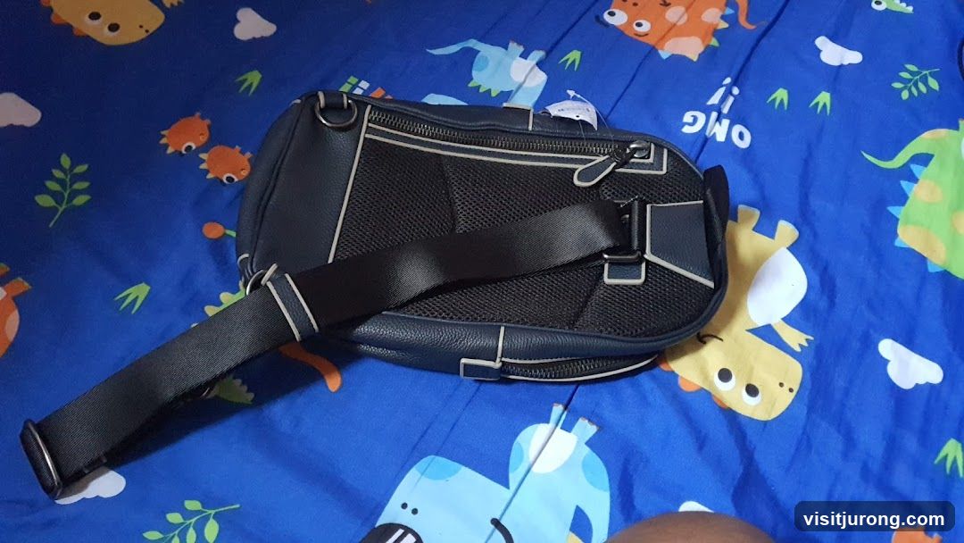 Blue sling bag on dinosaur-themed blanket