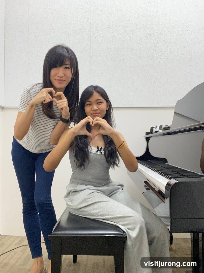 Two people making heart shapes with their hands near a piano