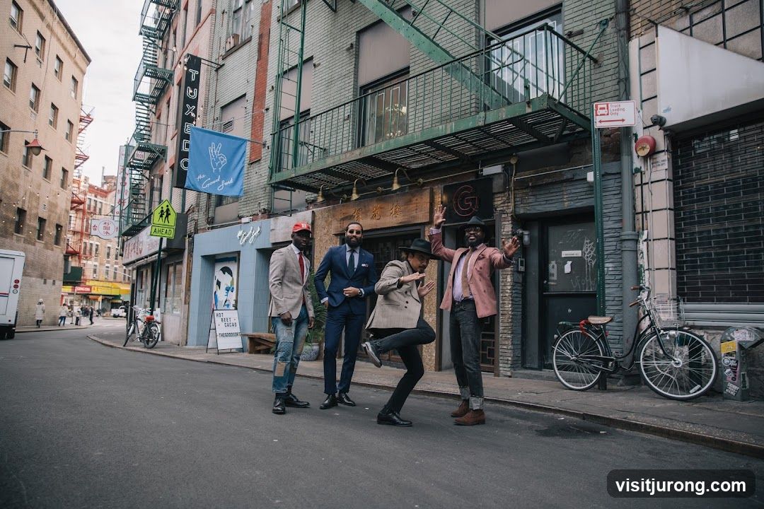 Four men posing on a street in front of a building