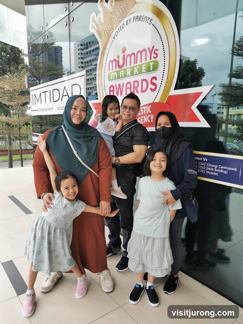 Family Posing in Front of Mummy's Market Awards Signage