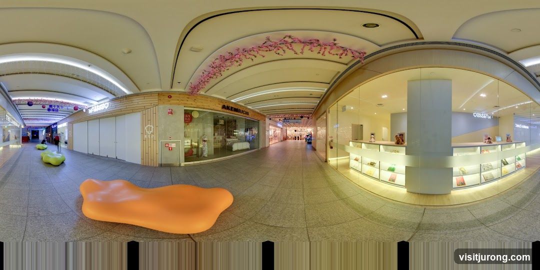 Shopping mall interior with storefronts and seating