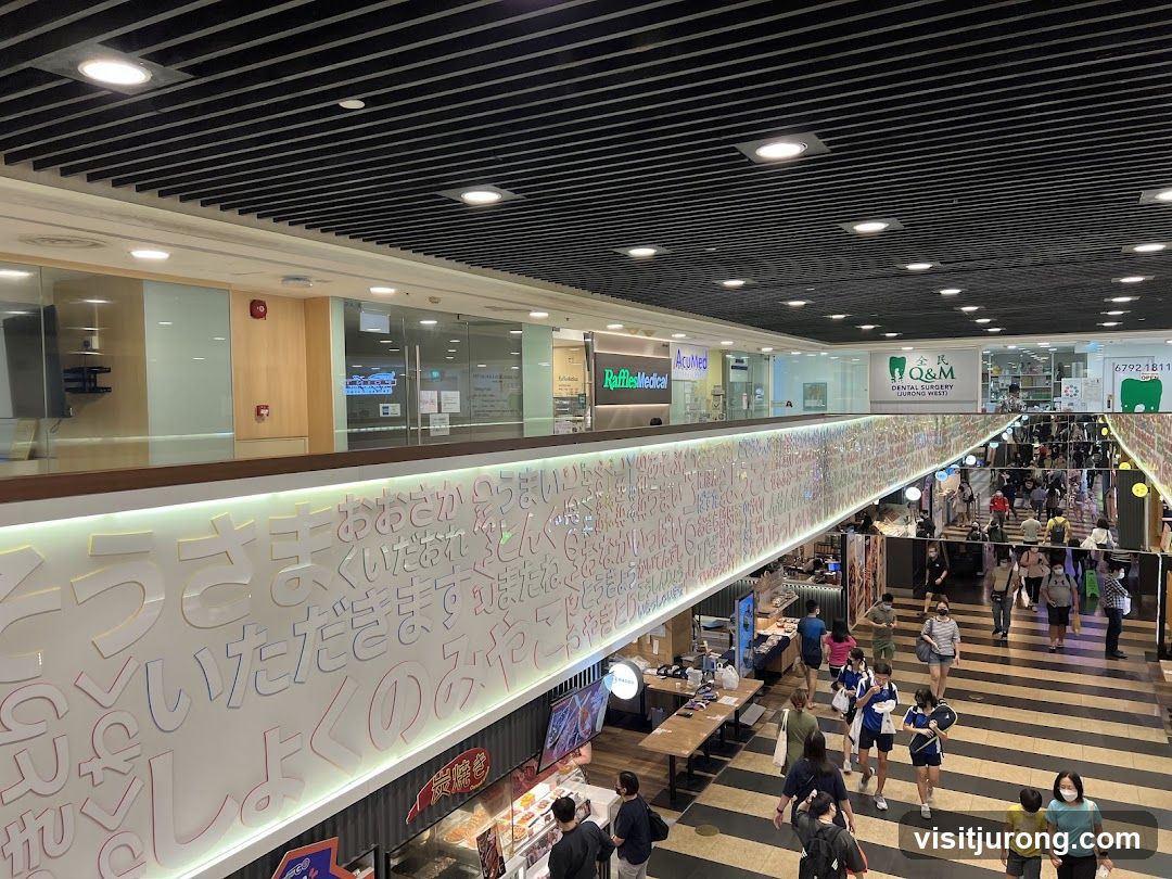 Indoor shopping mall with various shops and people