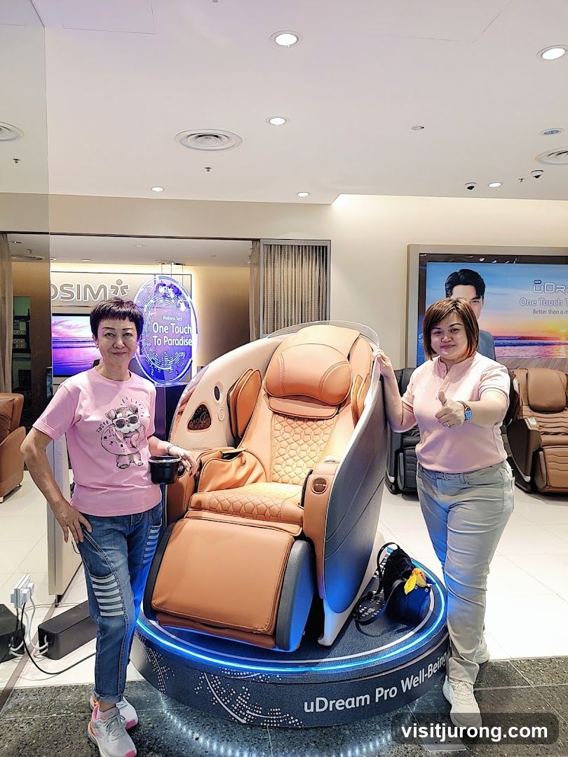 Two women posing with a massage chair