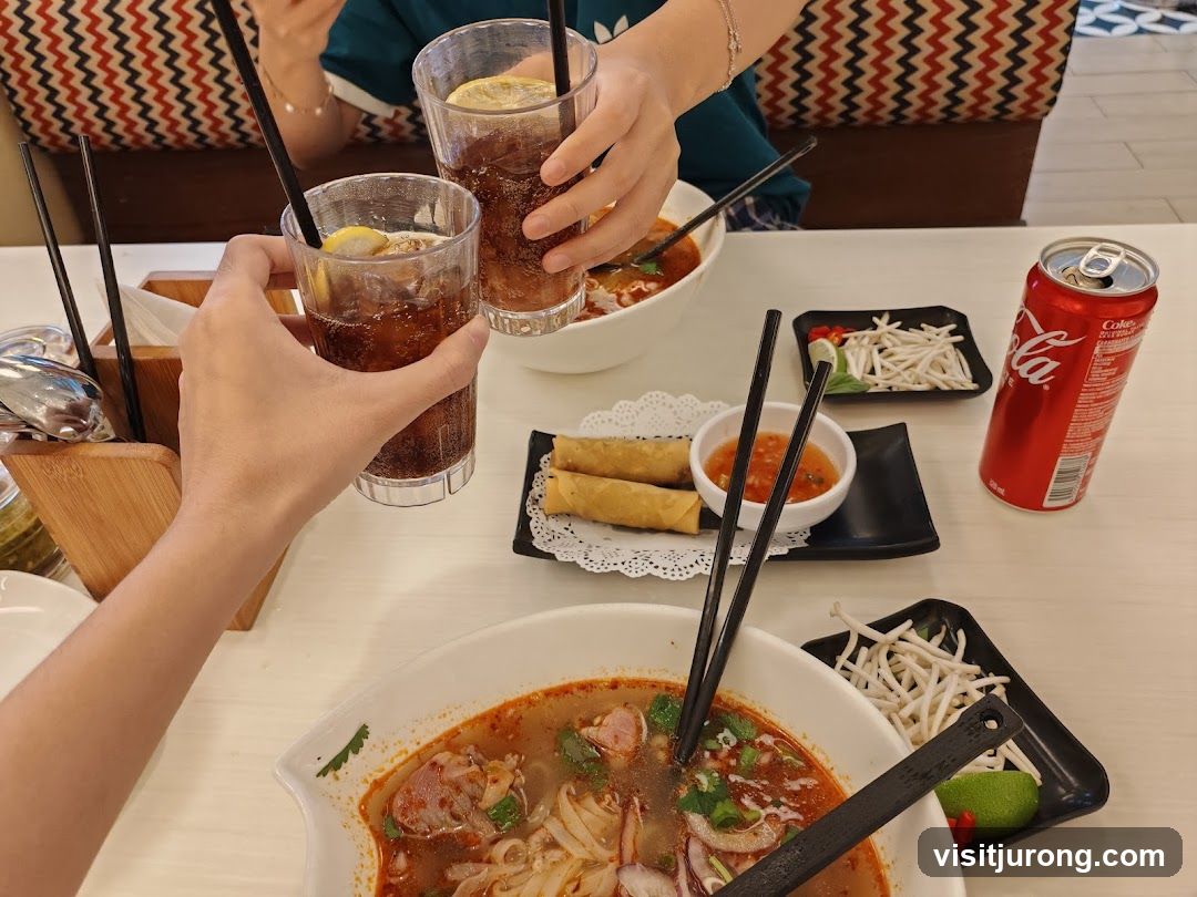 People toasting with drinks at a table with food