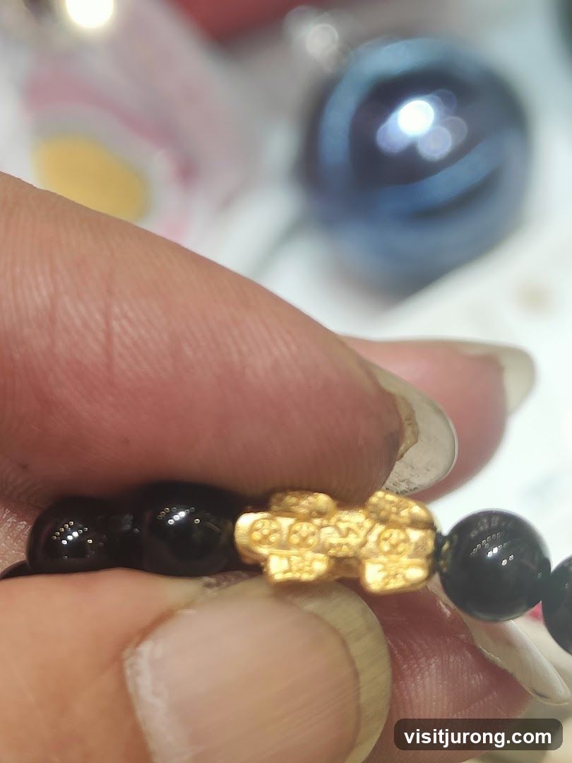 Close-up of a bracelet with black beads and a gold charm