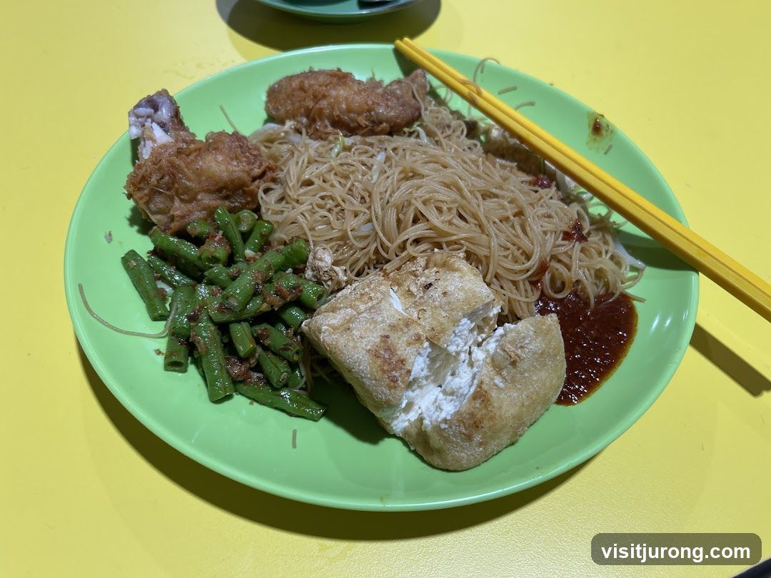 Plate of noodles with fried chicken and vegetables