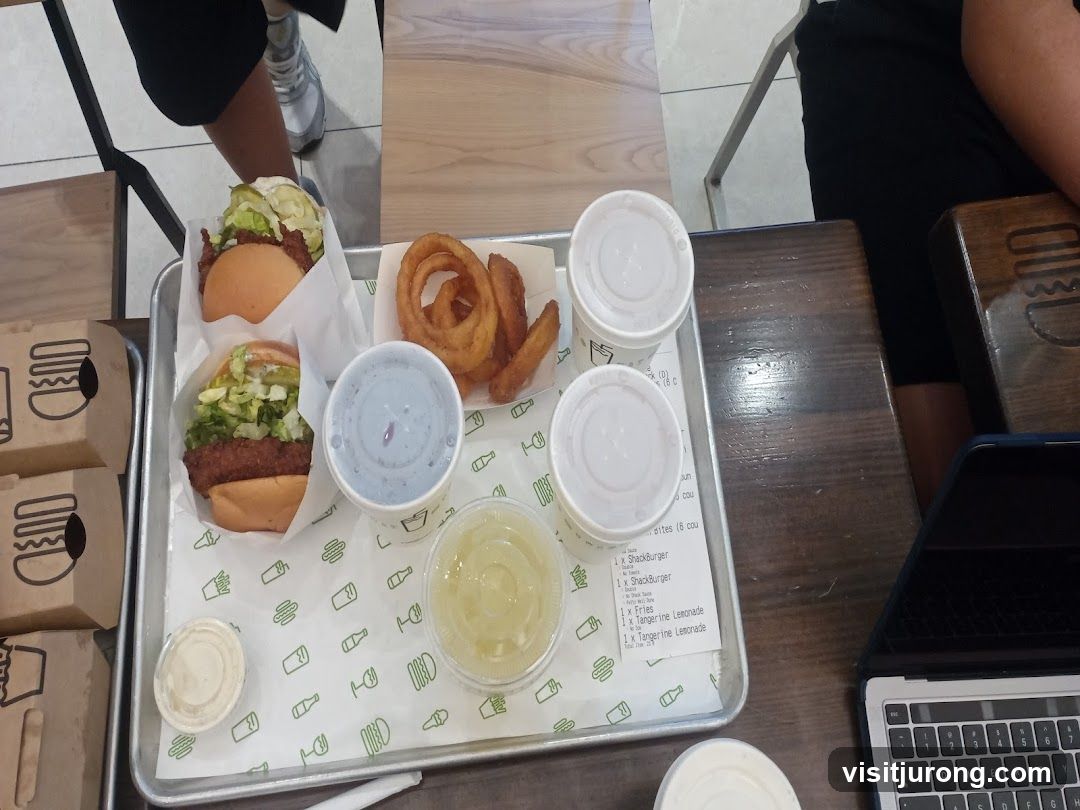 Tray of food with burgers, fries, and drinks
