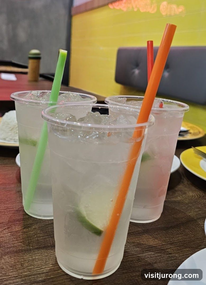 Three iced drinks with lime and straws