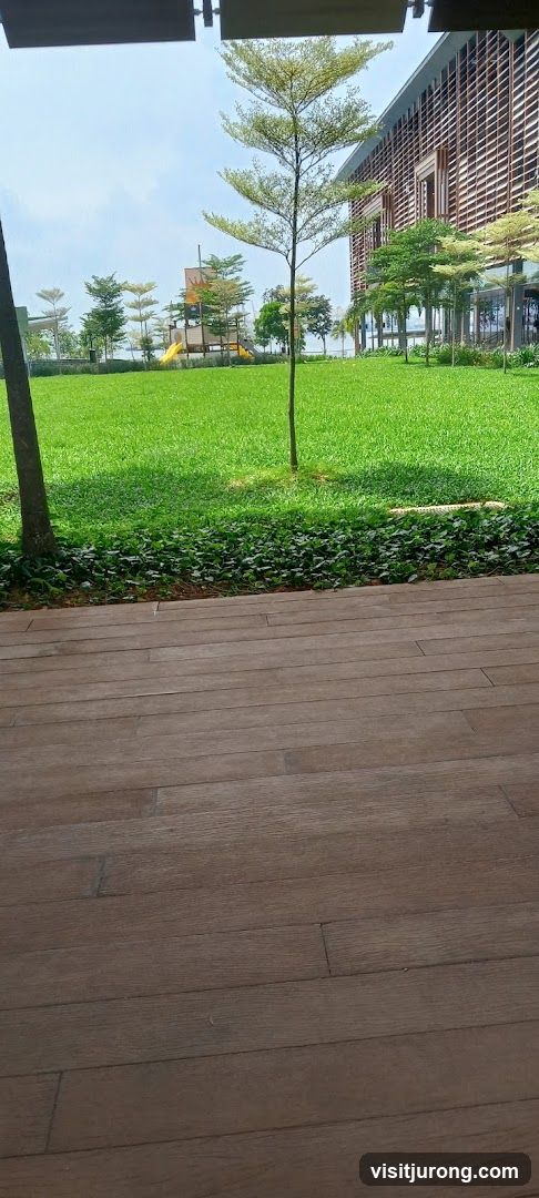 Outdoor seating area with a view of a playground and modern building