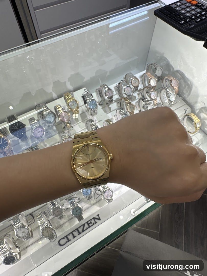 Person wearing a gold Tissot watch