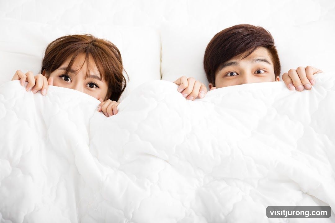 Couple peeking from under blanket